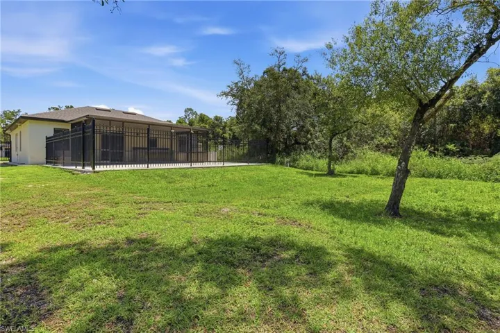 Expansive backyard featuring a large screened patio and mature trees