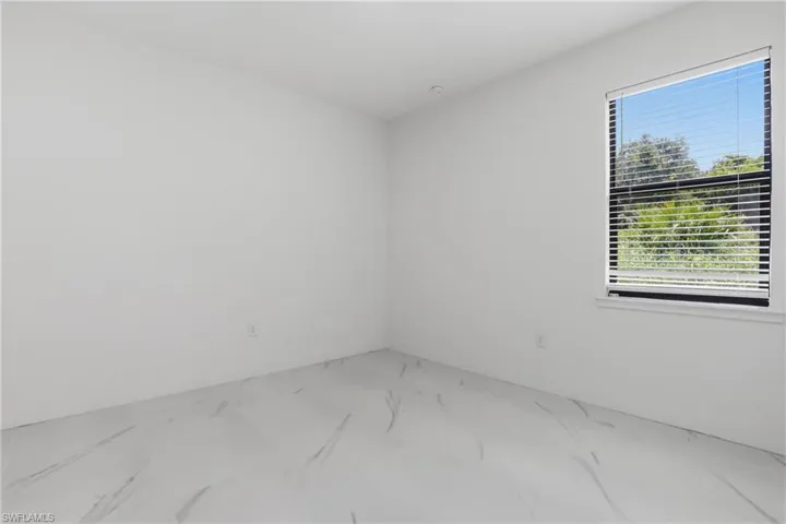 Bright room featuring white walls and a single window