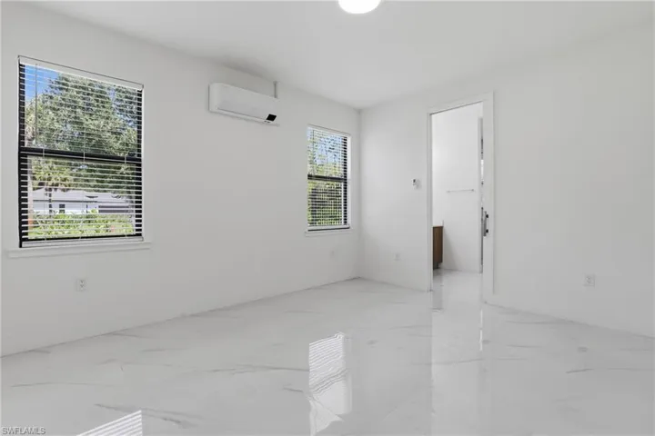 Bright interior space featuring white walls and polished marble-look flooring