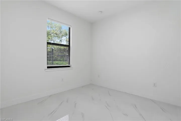 Room featuring a white interior and large window with horizontal blinds