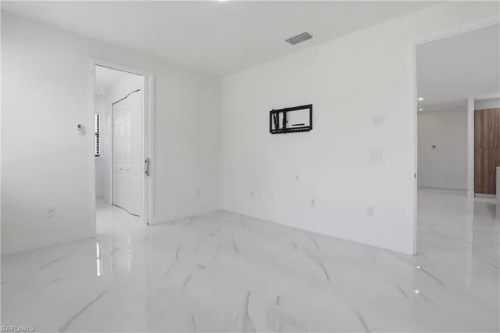 Bright interior space featuring white walls and marble-look tile flooring