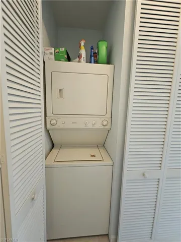 Laundry area with stacked washer and clothes dryer