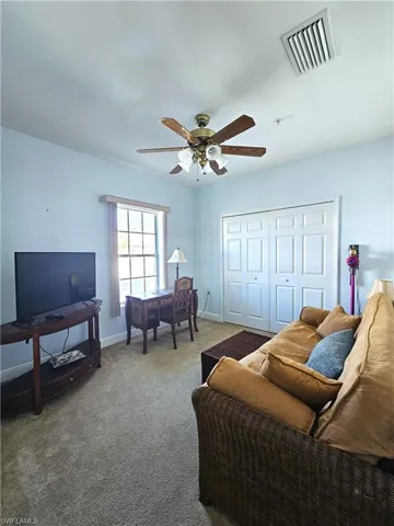 Living area featuring carpet flooring and a ceiling fan