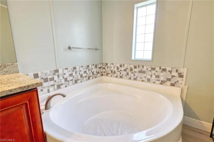 Bathroom featuring vanity and a tub