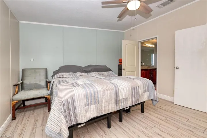 Bedroom with crown molding, ceiling fan, and light hardwood / wood-style floors