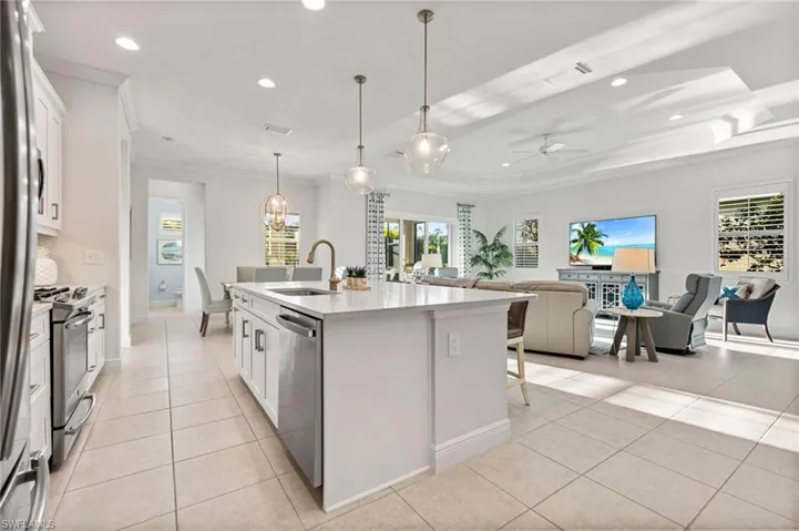 Kitchen featuring a sink, appliances with stainless steel finishes, light tile patterned flooring, and crown molding
