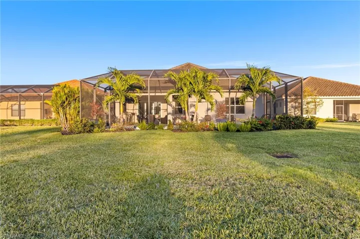 View of front of home with glass enclosure and a front yard