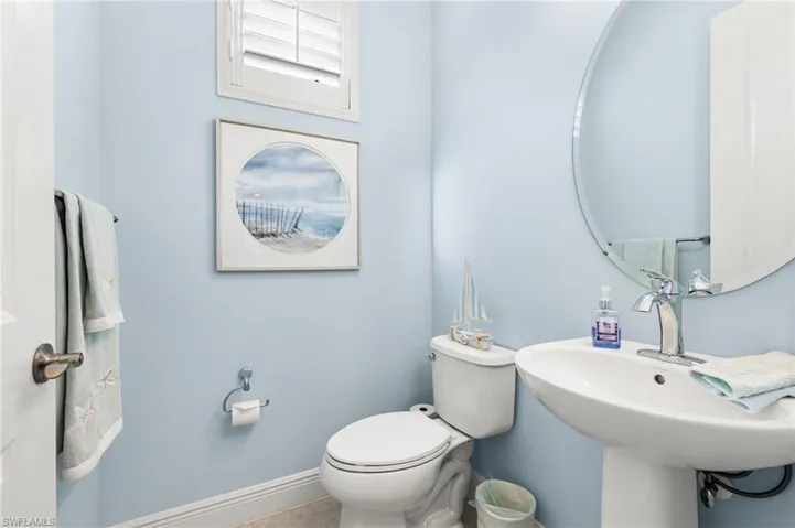Bathroom with toilet, baseboards, and a sink