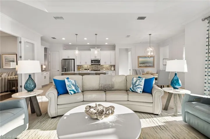 Living area featuring crown molding, recessed lighting, and visible vents