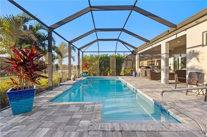 Outdoor pool with a lanai and a patio