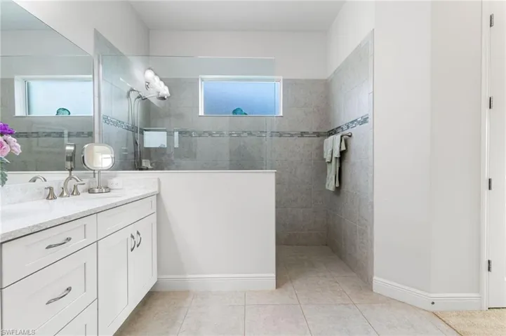 Full bathroom featuring a wealth of natural light, walk in shower, and vanity