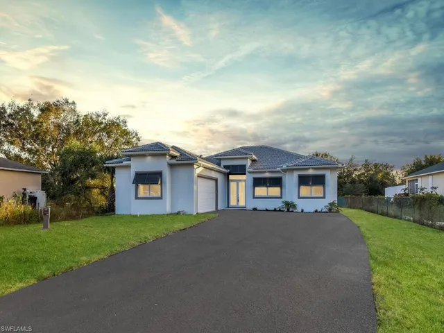 View of front facade with a garage and a lawn,12’ wide right-side access to drive to the back of the property.