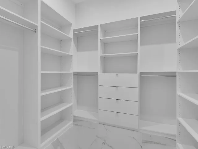 View of walk in closet in primary bedroom.