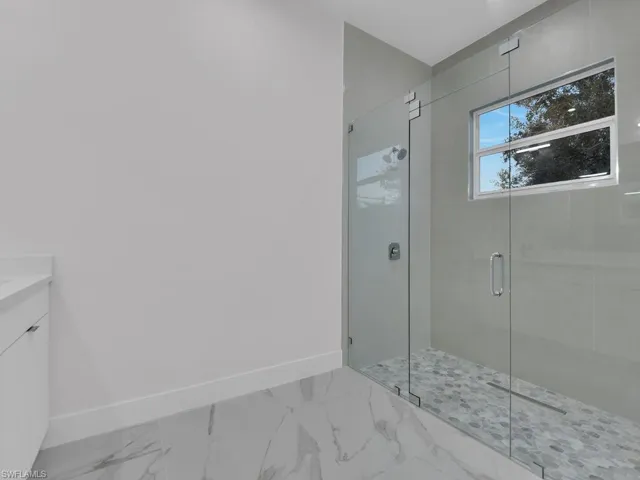 Bathroom featuring vanity and a shower with shower door