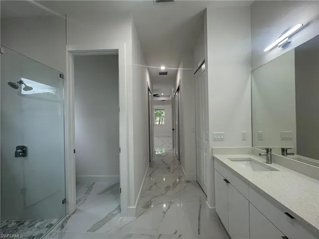 Primary Bathroom featuring a stall shower, baseboards, visible vents, floor, and vanity