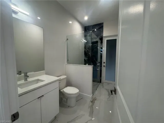 Guest Bathroom featuring vanity, toilet, and tiled shower