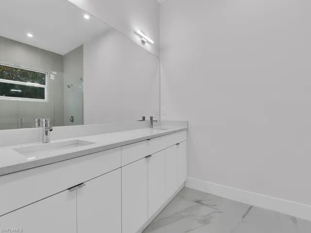 Bathroom with vanity , double sink, and a shower with shower door
