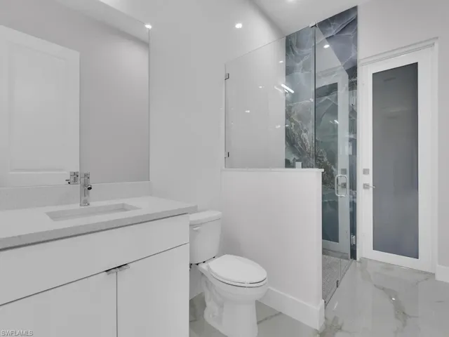 Guest Bathroom with walk in shower, vanity, and toilet