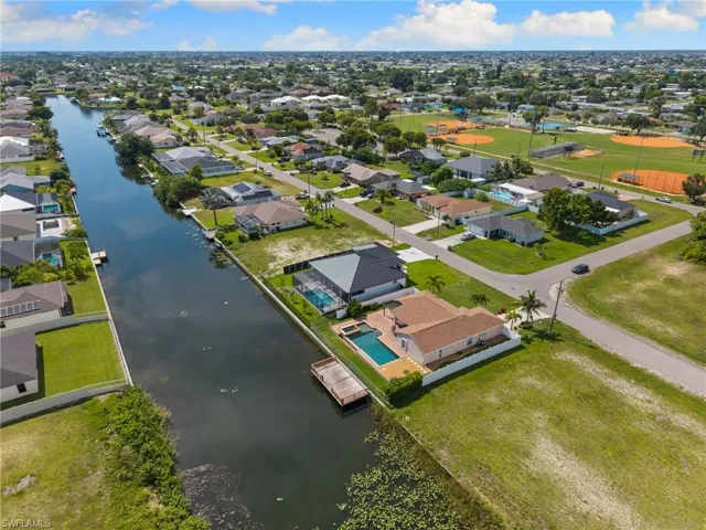 Waterfront residence with a private swimming pool, fenced yard, and a wooden dock