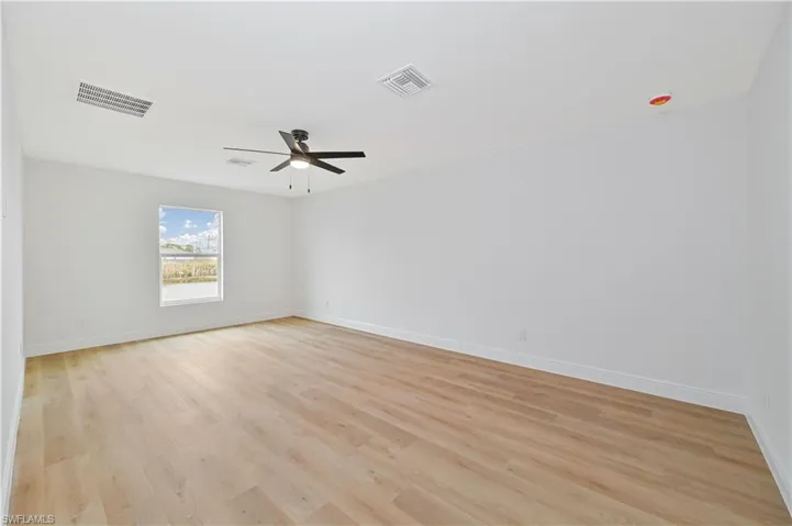 Empty room featuring light wood finished floors and ceiling fan