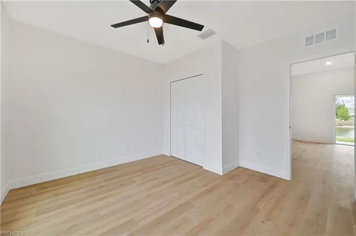 Unfurnished bedroom with light wood-type flooring, a ceiling fan, and a closet