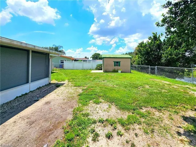 Fenced backyard with an outbuilding