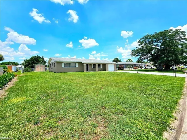 Ranch-style home featuring stucco siding, concrete driveway, a front lawn, and an attached garage