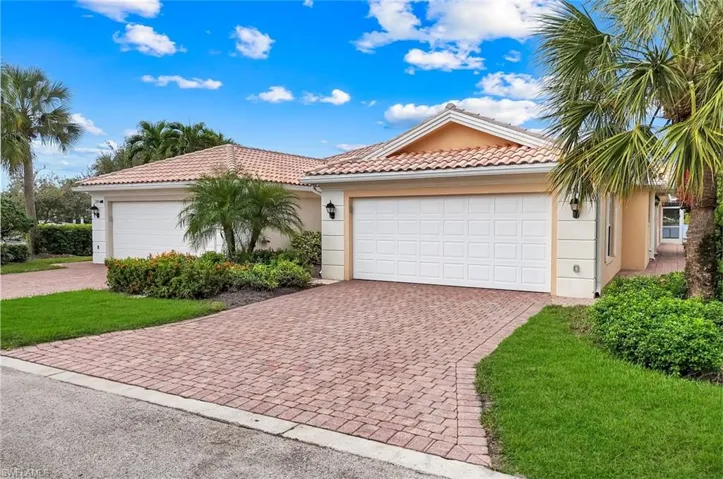 View of front of home with stucco siding, a tiled roof, private driveway at the end of the "T" and a two car garage