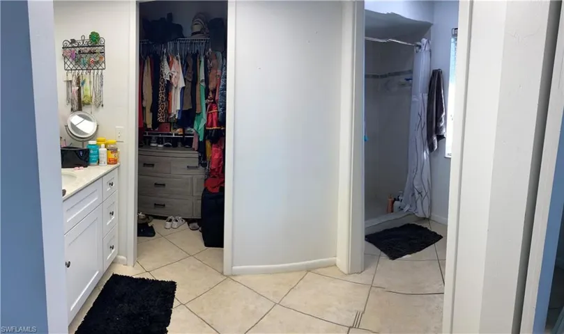 Bathroom featuring tile patterned floors, vanity, and curtained shower