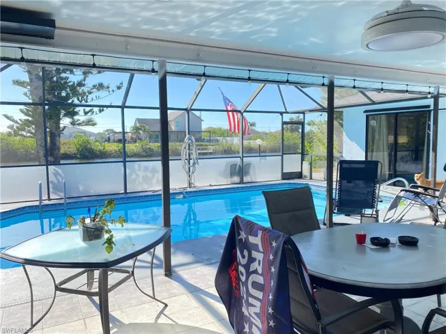 View of pool featuring glass enclosure and a patio area
