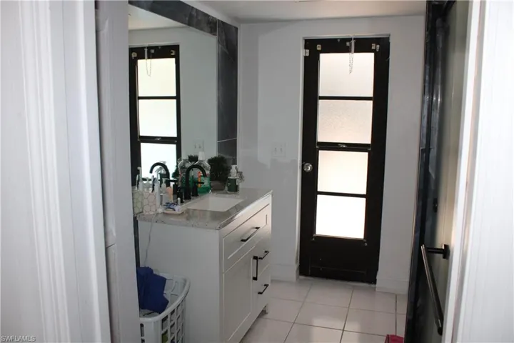 Bathroom with vanity, tile patterned floors, and plenty of natural light