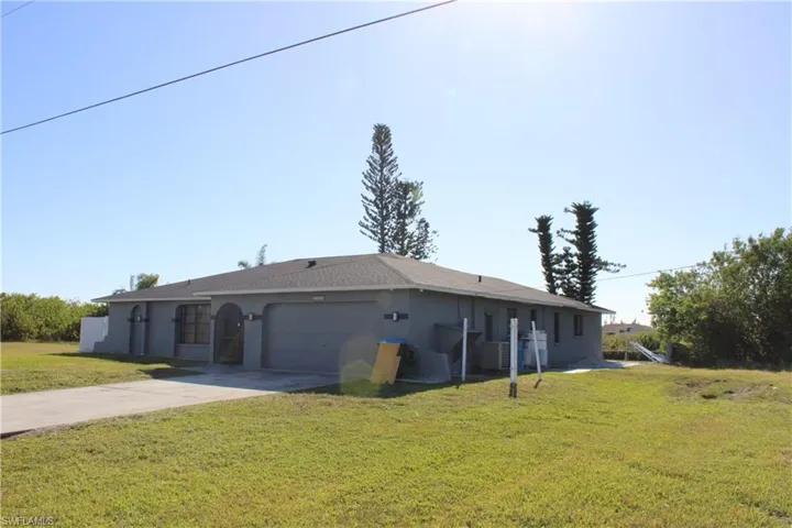 Single story home featuring a front yard, a garage, and central AC unit
