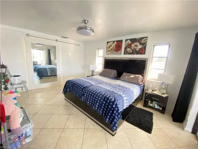 Tiled Master bedroom featuring ceiling fan