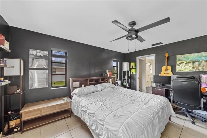 Bedroom with light tile patterned flooring and ceiling fan