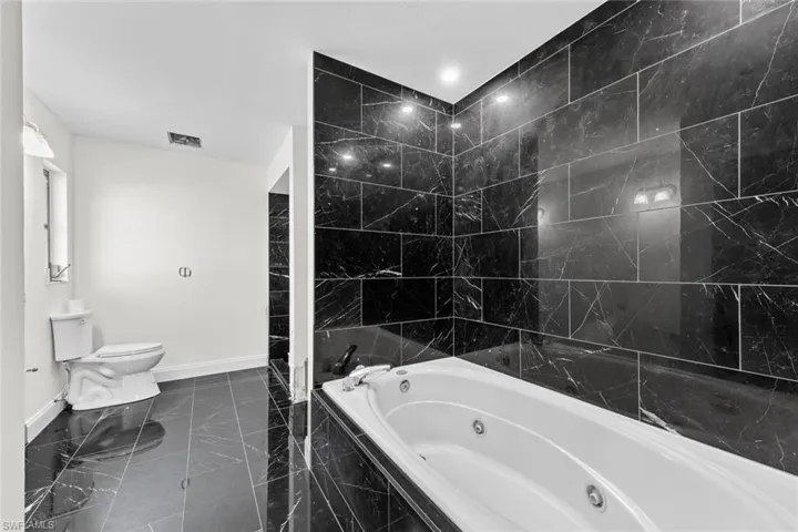 Bathroom featuring separate tiled bath, double sink with space for a make up desk, HUGE walk-in closet.
