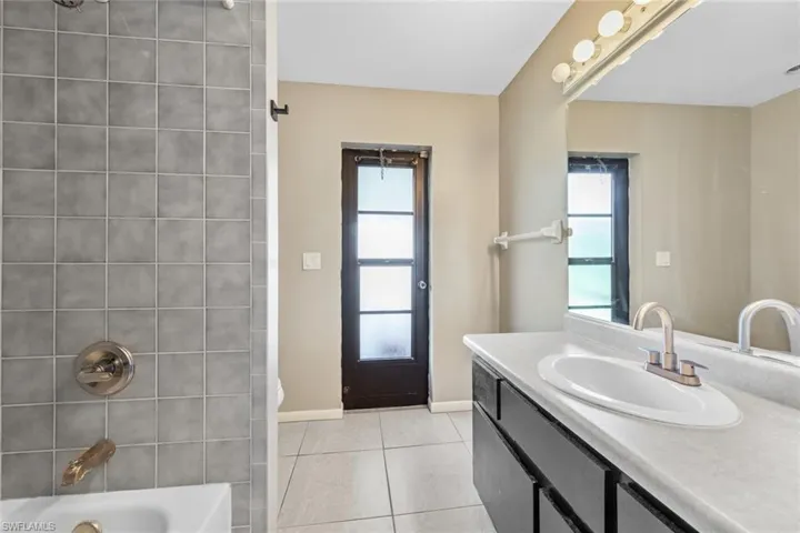 Bathroom featuring shower / bath combination, vanity, and tile patterned floors