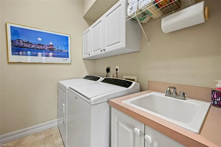 Laundry room with sink and cabinet.