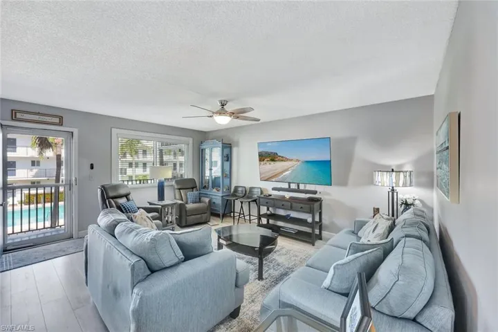 Living area featuring a textured ceiling, ceiling fan, and wood finished floors