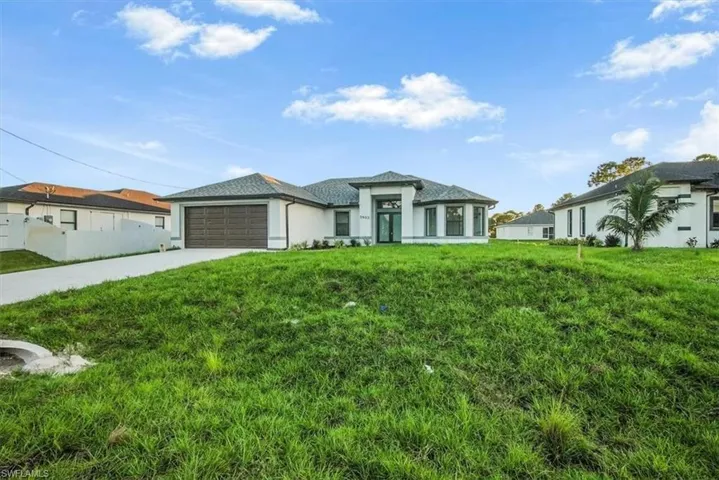 Prairie-style home featuring a front yard, driveway, and an attached garage