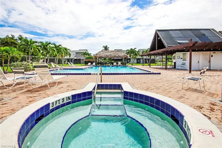 Community pool featuring a hot tub, a gazebo, and a patio area