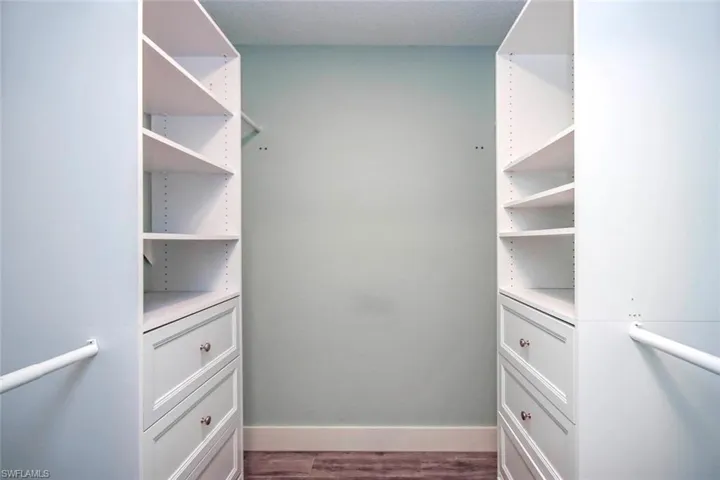 Primary walk-in closet with built in stoarage
