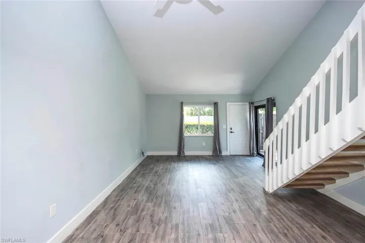 Large grat room with plank tile floor , impact with and sliders with high ceiling
