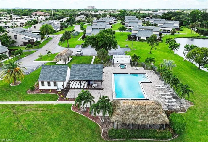 Aerial perspective featuring a community pool and a nearby pond