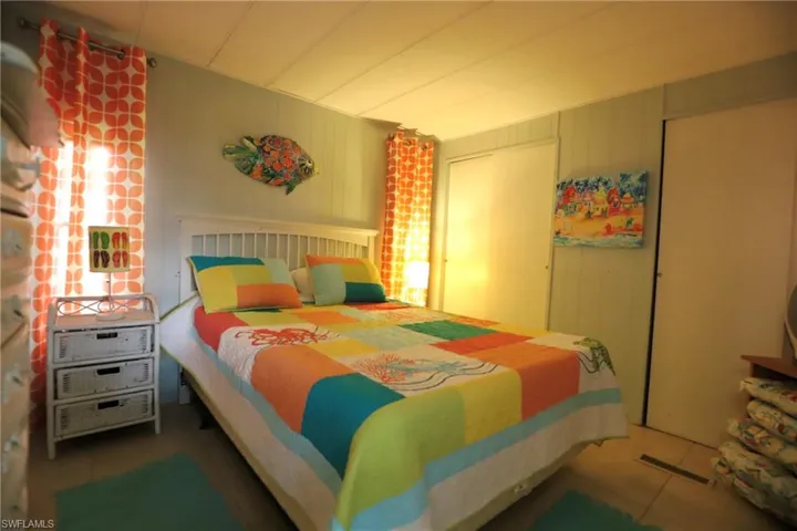 Tiled bedroom featuring wooden walls and a closet