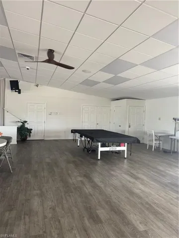 Recreation room featuring a ceiling fan and a paneled ceiling