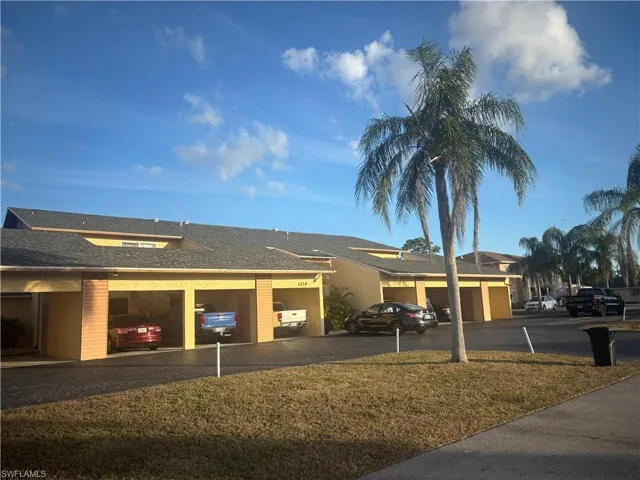 View of front facade featuring roof with shingles, driveway, and a garage