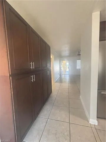 Hallway featuring light tile patterned floors and baseboards