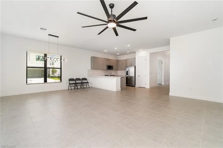 Living area with ceiling fan, light tile patterned flooring, and recessed lighting