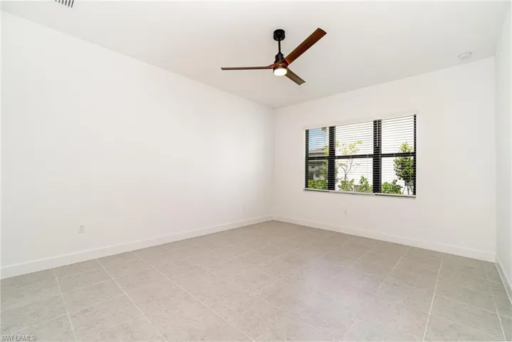 Spare room with ceiling fan and light tile patterned floors