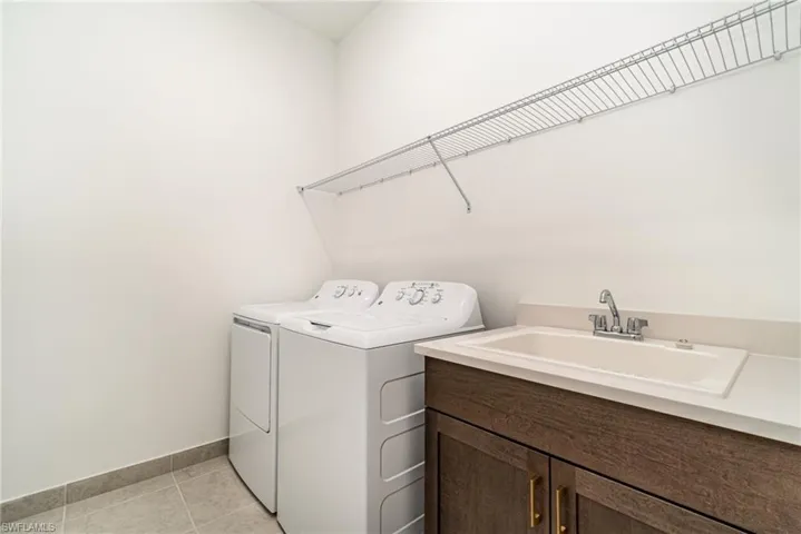 Laundry room with washer and dryer and light tile patterned floors
